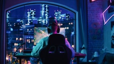 Başarılı bir eSports Gamer 'ın Baş Açısı' nın Evdeki Bir Neon Lit Oturma Odasında Kişisel Bilgisayarda Bir Video Oyunu Oynuyor. Evdeki Sıcak Gece