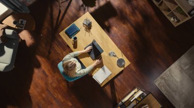 İçişleri Bakanlığı 'nın En İyi Görünümü: Serbest Girişimci Masada Oturuyor, Dizüstü bilgisayar kullanıyor. Evden Kadın Profesyonel Çalışmalar, Uzaktan Şirket Yönetimi, Tasarımlar