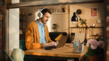 Laptop kullanan düşünceli adam, İç İşleri 'nde uzaktan çalışırken Kulaklıkla Eğitici Ses Podcast' i dinliyor. Şık Profesyonel Yapım