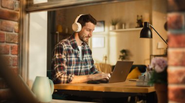 Modern Freelancer Kulaklık Giyiyor ve Laptop 'ta Yazıyor, Sosyal Medya İçin İçerik Oluşturuyor. Girişimci İçişleri Bakanlığı 'nda uzaktan çalışıyor, yönetiyor.