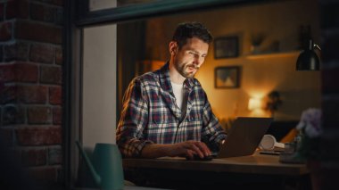 İçişleri Bakanlığı 'nda Dizüstü bilgisayar üzerinde çalışan ciddi bir adam önemli bir proje bitiriyor. Serbest Çalışan Uzaktan Kumanda. Sıcak Aydınlık Konforlu Daire