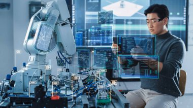 Bilgisayar Bilimi Geliştirme Mühendisi Tablet Bilgisayar kullanarak Robot Kolu programlıyor ve çalıştırıyor. VFX Artırılmış Gerçeklik Arayüzleri ve Simgeleri Göster