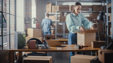 Küçük işletme sahibi şık sarı bir ceket paketliyor ve internetten bir müşteriye satılıyor. Posta için küçük bir karton kutu hazırlıyorum. Güzel Dişi