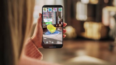 Dekorasyon Apartmanı: Akıllı Telefonu Tutan Kadın, Artırılmış Gerçeklik İç Tasarım Yazılımı ile Ev için 3D Mobilya Seçiyor. Şık bir sandalye seç.