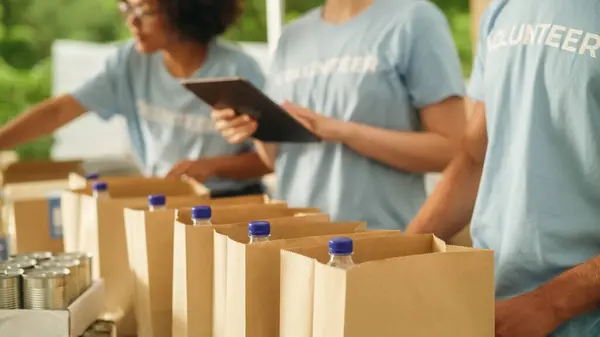 stock image Close Up Footage of a Group of Volunteers Preparing Free Food Rations for Poor People in Need. Charity Workers and Members of the Community Work