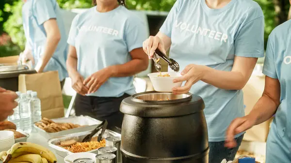 stock image Humanitarian Organization: Close Up of Volunteers Preparing Free Meals and Feeding Local Community that is in Need. Charity Workers Serve Noodles