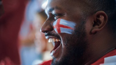 Spor Stadyumu Spor Etkinliği: Kırmızı Takım İçin Boyalı Tezahürat Yapan Yakışıklı Siyah Adam 'ın Yakın Çekim Portresi, Zaferi Kutlarken Çığlık