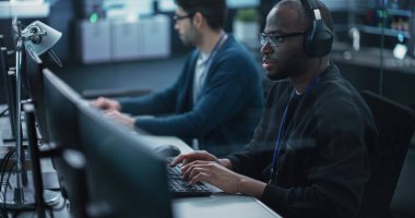 Afrika kökenli soru-cevap mühendisi, fırlatmadan önce bir ürün veya programda hataları bulup düzeltiyor ve iş birliğiyle konuşuyor. Genç Siyah