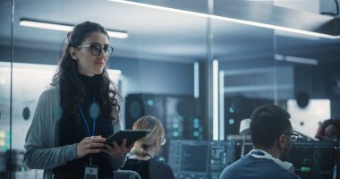 Teknolojik Yazılım Mühendisliği Müdürlüğü Yürüyen ve Tablet Bilgisayar Kullanımı. Ofiste çalışan çok ırklı bir kadın.