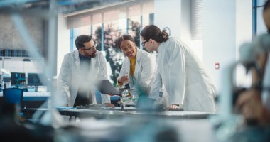 Bir şirket laboratuvarında çalışan çeşitli genç mühendisler grubu. Proje Yöneticileri, Kadın Uzman Olarak Dizüstü bilgisayar Kullanımı İmalatını Tartışıyor