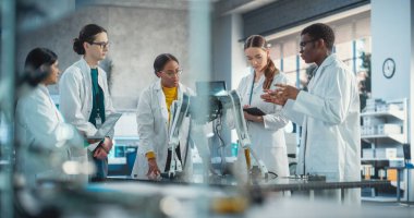 Modern Fabrika Geliştirme Atölyesinde Endüstriyel AI Robot Köpeğini Tartışan Profesyonel Genç Kadın ve Erkek Mühendisler Ekibi. Teknoloji