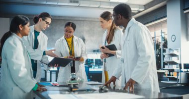 Laboratuvar Önlüklü Mühendisler Laptop ve Tablet kullanarak Elektronik Bileşenler için Beyin Fırtınası Fikirleri. Endüstriyel Robot Uzmanlarının Çeşitli Ekibi