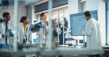 Çeşitli Erkek ve Kadın Takımları Teknolojik Başlangıç Laboratuvarında Fikirleri Tartışıyor. Uluslararası Öğrenciler Grubu Robot Bilimleri Profesörlerini Dinliyor