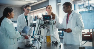 Çeşitli Endüstriyel Robot Uzmanları Mobil bir robotla bir masanın etrafında toplandı. Laboratuvar Önlüklü Mühendisler Otomatik Yapay Zeka Robotunu Tartışıyor