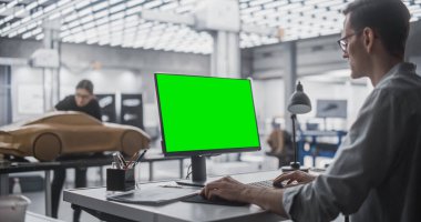 Otomotiv Tasarımcısı Yeşil Ekran Model Görünümü ile Masaüstü Bilgisayarı üzerinde çalışıyor. Dijital Sanatçı Bir Stüdyoda Konsept Araç Oluşturuyor. Modelleyici