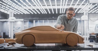 Yaratıcı Otomotiv Tasarımcısı Polymer 'dan çıkan bir prototip araba üzerinde çalışıyor Clay' i modelliyor. Odaklanmış Profesyonel Modelleyici 3D Heykeli Düşünüyor