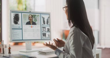 Çevrimiçi Doktorlar Kabinesinde Tıbbi Danışmanlık: Asyalı Hekim Masaüstü Bilgisayarında Bir Hastayla Konferans Görüşmesi Yapıyor. Sağlık Hizmetleri