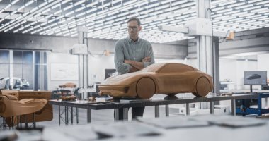 Otomotiv Tasarımcısı, Polymer Modelleme Clay 'den prototip bir araba yaratmak için bir Spatula kullanıyor. Bir Araştırma Geliştirmede Odaklanmış Modelleyici