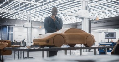 Yakışıklı bir Otomotiv Tasarımcısının Portresi Yeni Bir Yapım Arabasının 3 boyutlu Clay Modelini Geliştiriyor. Profesyonel Siyah Adam Tamamlanmış Prototipine Bakıyor