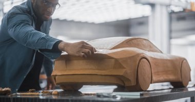 Plastikten yapılmış, çamurdan yapılmış bir konsept araba üzerinde çalışan siyah bir araba modelinin portresi. Yetenekli Tasarımcı Spatula 'yı kullanarak