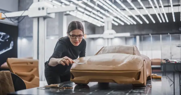 Stock image Portrait of a Female Automotive Designer Sculpting a 3D Clay Model of New Production Car. Young Woman Using a Spatula to Carefully Trim the Surface of