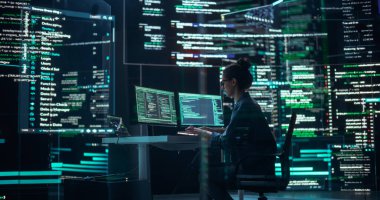 Bir İzleme Kontrol Odasında Çalışan Profesyonel Kadın Programcı, Programlama Dili Kodunun Çizgilerini Gösteren Büyük Ekranlarla çevrili. Portre