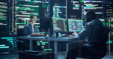 Bilgisayar üzerinde çalışan iki farklı geliştiricinin portresi, onları çevreleyen büyük ekranlarda görünen kod satırları yazıyor. Erkek ve Kadın Programcılar