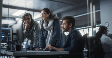 Üç Genç Hint Yazılım Mühendisleri Grubu Modern Endüstriyel Ofis 'teki Teknolojik Projeyi tartışmak için Bilgisayar kullanıyor. Erkek ve Kadın Grupları