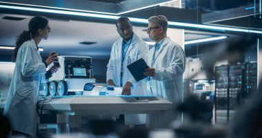 Çeşitli Endüstriyel Robot Uzmanları Mobil bir robotla bir masanın etrafında toplandı. Laboratuvar Önlüklü Mühendisler Otomatik Robot Tartışması