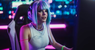 Gülümseyen Kostümcü Kız Futuristik Siberpunk Evi 'nde otururken Çevrimiçi Arkadaşlarıyla Masaüstü Bilgisayarında Konuşuyor. İnternet Videosu Oynayan Genç Kadın