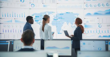 Çeşitli Veri Bilimleri Bölümü Dünya Haritası Ofisi 'nde Büyük Dijital Ekran önünde yeni pazarları tartışıyor. Çoklu Etnik