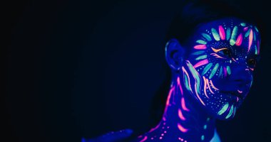 Yenilikçi Güzellik Reklamcılığı: Yetenekli Model Gösterileri Onun Eşsiz Tarzı, Neon Boyalı Vücut ve Yüzü Karanlık Arkaplan ile Güzelce Çelişkili