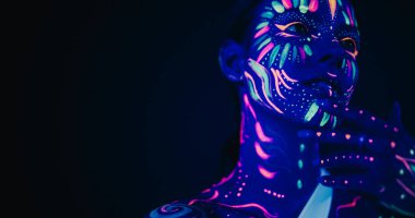 Güzellik Yakından Fotoğraf: Kendine güvenen Genç Kadın Pozisyonları, Alçak Anahtarlı Stüdyo Ayarlarına Karşı Yüz Özelliklerini vurgulayan Neon Boyası