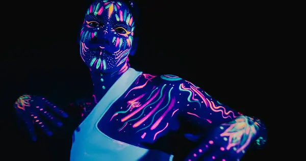 stock image Young Dancer Delivers Captivating Improvised Contemporary Dance Performance, Adorned in Vibrant Neon Body Paint and White Clothes, Against an Abstract