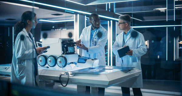 Команда инженеров-технологов, работающих над роботом мобильности на пусковом заводе. Мультиэтнические ученые мужского и женского пола обсуждают автоматизированный ИИ