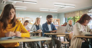 Özenli Hintli Öğrenci Ders Dinliyor ve Sınıfta Dizüstü Bilgisayarda Ders Yazıyor. Yetişkin Erkek ve Kadın Uzmanlık Bilgisi Alınıyor