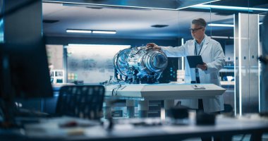 Jet Motor Uzmanı Fütüristik Türbin Motorlu Bir Proje üzerinde çalışıyor, Bilimsel Teknoloji Laboratuvarında Tablet Bilgisayar ile Duruyor. Orta Çağ