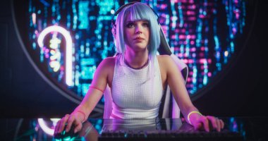 Çekici Cosplay Kızı, Futuristik Siberpunk Evi 'nde otururken Masaüstü Bilgisayarında Diğer Oyuncularla İnternet Oyunları Oynuyor. Genç Dişi