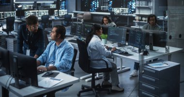 Genç Güney Asyalı Uzmanlar Ekibi Bilgisayarlar ve İş yerinde Sohbet Etme üzerine Çalışıyor. İki Erkek Yazılım Geliştiricisi