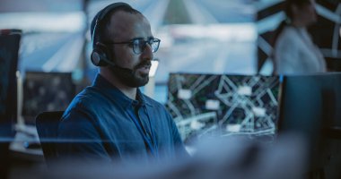 Çoklu etnik çeşitlilikte erkek memur, bir bilgisayarın güvenlik kamerası görüntülerinde çalışıyor. Trafik Gözlem Merkezi 'nde büyük bir dijital kamerayla ilgili birden fazla bilgi var.