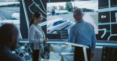 İki Çoklu Etnik Yazılım Mühendisi Modern İzleme Ofisi 'nde Büyük Ekran Başında Trafiğin İçinde Olduğu Canlı CCTV Görüntüleriyle Konuşuyor