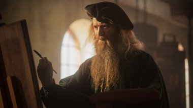 Atölyesinde tuvale resim çizen bir erkeğin orta boy portresi. Rönesans Dönemi 'nin Ünlü Ressamı İlham Veriyor ve Ekliyor