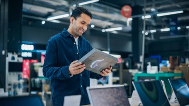 Ev Elektronik Mağazasından Tablet Alacak Yakışıklı Genç Adam. Bilgisayar Özellikleri, Satış Fiyatları ve Ekran Kalitesi Karşılaştıran Çok Irklı Müşteri