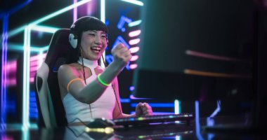 Internet Streamer, Sosyal Medya Kanallarında Canlı Video Oyunu Yayını Yapıyor. Fütürist Neon ile Bir Odada Masaüstü Bilgisayarı Kullanan Güzel Kız