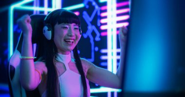 Japon Online Gamer, Futuristik Siberpunk Odasında Bir Video Oyunu Oynuyor. Pro Gamer 'ın Raundu Kazanması ve Kutlaması. Kostümlü Kız Kulaklık Kullanıyor