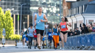 Şehir Maratonuna Katılan Mutlu İnsanlar Grubu. Çeşitli Yarış Koşucuları Bitiş Çizgisi 'ne ulaşıyor, Zaferlerini kutluyor ve