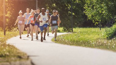 Bitiş çizgisi için yarışan Çeşitli Katılımcıların Geniş Çekimi: Park Sağlık Patikasında Koşan İnsanlar ve