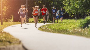 Bitiş çizgisi için yarışan Çeşitli Katılımcıların Geniş Çekimi: Park Sağlık Patikasında Koşan İnsanlar ve
