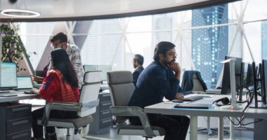 Genç Hint Uzman Takımı Bilgisayarlar ve Ofiste Sohbet Etme üzerine çalışıyor. Erkek ve Kadın Meslektaşlar Çözümü Tartışıyor