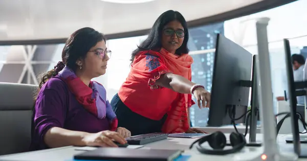 stock image Two Diverse Colleagues Having a Conversation While Busy Working on a Corporate Team Project. South Asian Female Designer Talking with an Indian